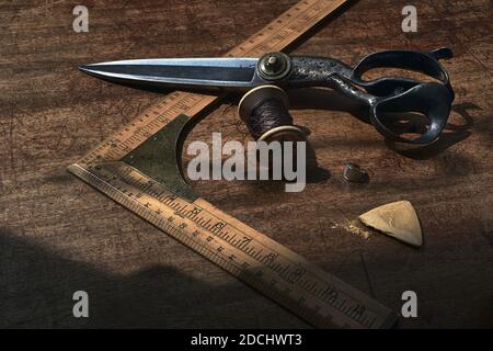 vintage ruler and scissors lying on wooden table at Poole & Co , Savile Row , London . Stock Photo