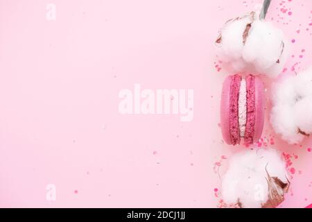 Pink pastel macaroon with cotton flower on glitter Stock Photo