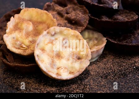 Chocolate coated hazelnut and rice florentines covered in cocoa powder.  White, milk and dark chocolate selection Stock Photo