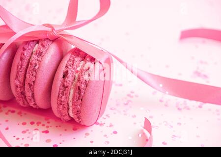 Pink macaroons wrapped in ribbon on glitter Stock Photo