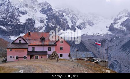 Front view of alpine refuge with Ortler mountain range and glacier in background. Text: Name of the shelter (Schaubachhütte, Rifugio Città di Milano). Stock Photo