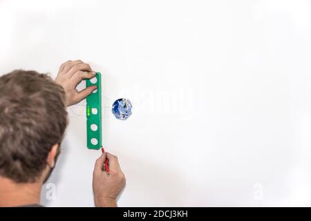 the employee makes the markings for the hole in the wall for the socket. Repair and electrical installation. Copy space. Stock Photo