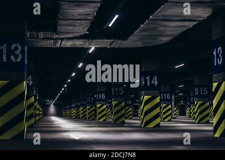 Underground parking under the supermarket, poles painted with green black stripes Stock Photo
