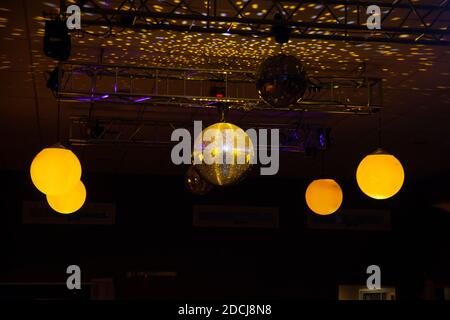 A low angle shot of bright glowing light balls hanging from a night bar ceiling Stock Photo