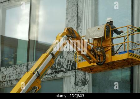 Man on hydraulic lift washing windows Stock Photo - Alamy