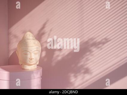White Buddha bust on pastel pink background Stock Photo