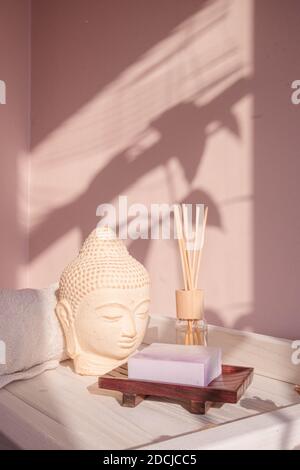 White Buddha bust on pastel pink background Stock Photo