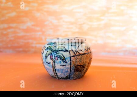 Beautiful palm painting in handmade pottery Ashtray on gradian yellow abstract background for house Decoration. Stock Photo
