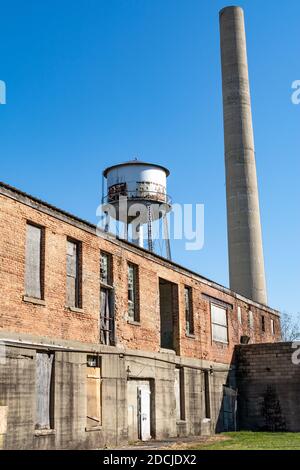 Old abandoned smoke stack and water tower in a derelict industrial area.  Amboy, Illinois. Stock Photo