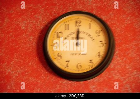 The clock is out of focus on a red background. Running time. Stock Photo