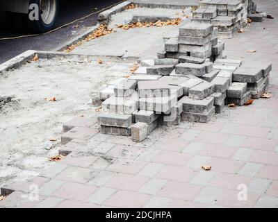 Sidewalk with not fully laid out paving slabs and stacked tiles on it Stock Photo