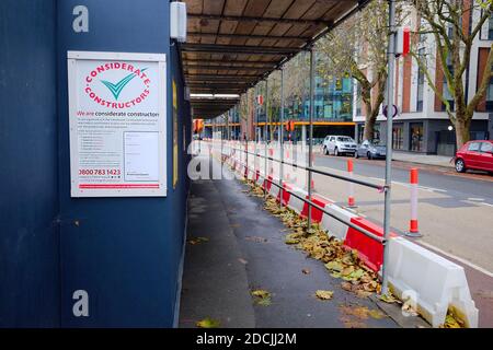 November 2020 - Considerate Constructors notice on the hoarding around a large construction site in Bristol, complete with protected walkway Stock Photo