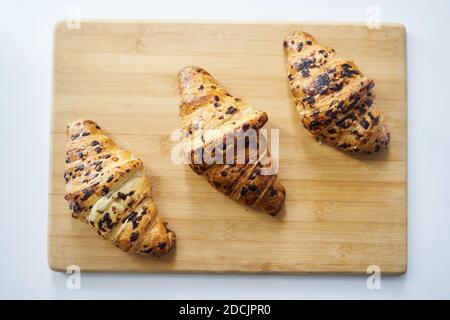 Close up of golden croissants on a wooden tray Stock Photo