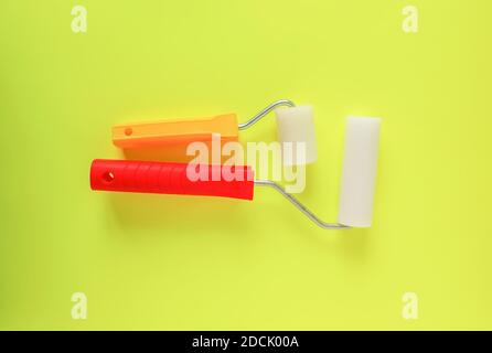 Home repair tools on bright yellow background. Two foam rollers for wall coloring close up. Stock Photo