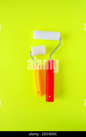 Home repair tools on bright yellow background. Two foam rollers for wall coloring close up. Stock Photo