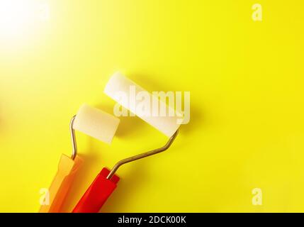 Home repair tools on bright yellow background. Two foam rollers for wall coloring close up. Stock Photo