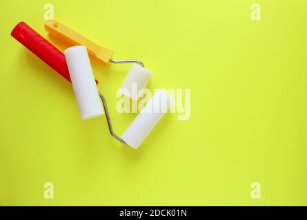 Home repair tools on bright yellow background. Two foam rollers for wall coloring close up. Stock Photo