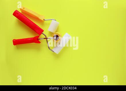 Home repair tools on bright yellow background. Two foam rollers for wall coloring close up. Stock Photo