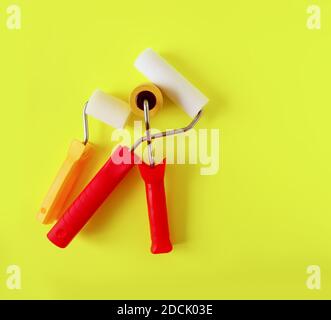 Home repair tools on bright yellow background. Two foam rollers for wall coloring close up. Stock Photo