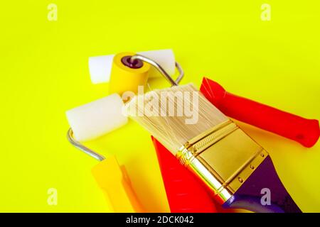 Home repair tools on bright yellow background. Foam rollers and synthetic brushes for wall coloring. Stock Photo