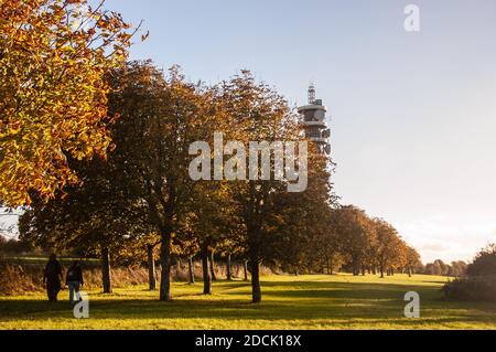 People walk under trees displaying autumn colours in Stoke Park in Lockleaze, Bristol. Stock Photo