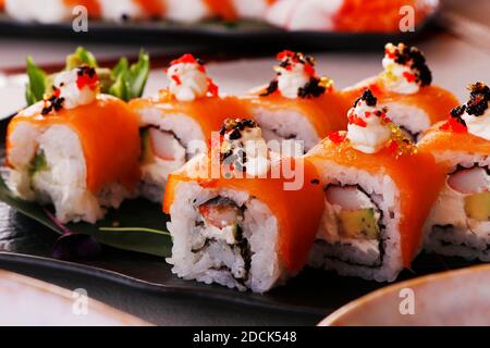 close up shoot of sushi rolls with avocado, crab, salmon, multi coloured eggs and soy sauce Stock Photo