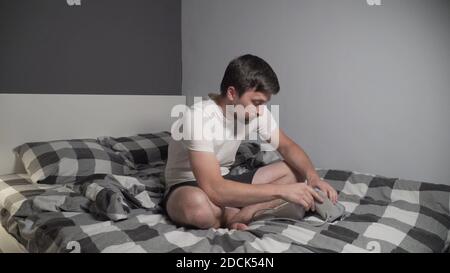 Young man measuring blood pressure at home. Hypertensive patient performing an automatic blood pressure test. Doing my regular checkup. High blood Stock Photo