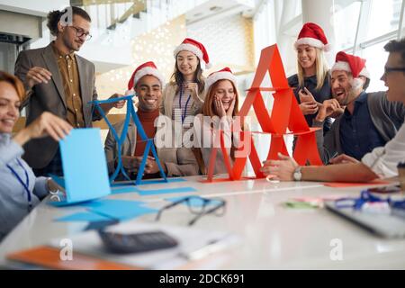 colleagues having fun at work for  christmas, building paper towers, playing Stock Photo