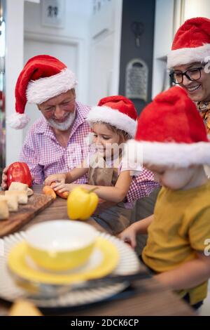 Grandpa and grandma like preparing Xmas meal with grandchildren in a festive atmosphere together. Christmas, family, together Stock Photo