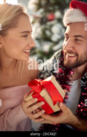 A lovely couple at home with a Xmas present on a beautiful holiday morning. Christmas, relationship, love, together Stock Photo