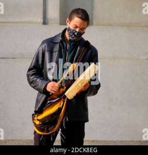First Nation young man wearing face mask playing traditional drum at a protest in Ottawa, Canada Stock Photo