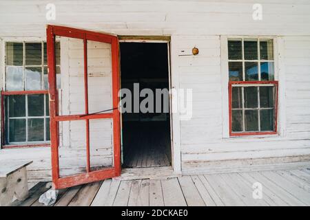 Old wooden red door propped open in an abandoned building in Bannack Ghost Town Montana Stock Photo
