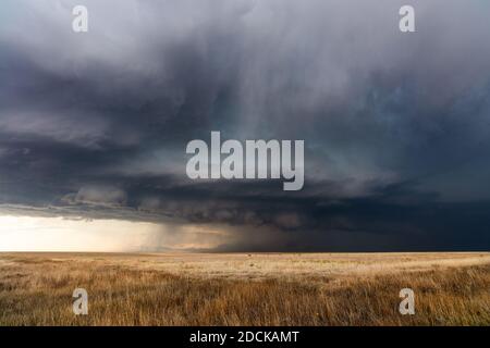 Stormy sky with dark storm clouds approaching over a field in Kansas Stock Photo