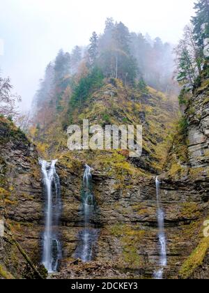 Waterfalls tumble over a rock face in the autumnal mountain forest near Hochnebel, Taugl or Tauglbach, Bad Vigaun, Tennengau, Salzburg, Austria Stock Photo