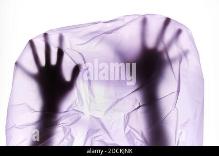 Silhouette of hands in plastic bag. Polyethylene Film. Plastic pollution and environmental problem Stock Photo