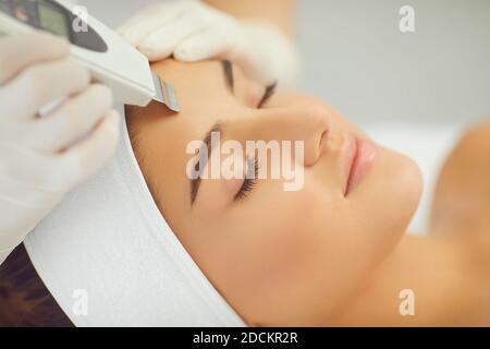 Close-up of relaxed womans face getting ultrasound apparatus facial cleaning Stock Photo