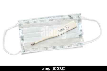 Electronic thermometer with high temperature lies on a face mask on a white isolated background Stock Photo