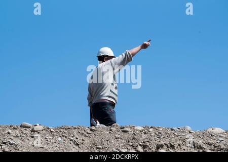 civil engineer pointing his finger to the blue sky at work on construction site Stock Photo