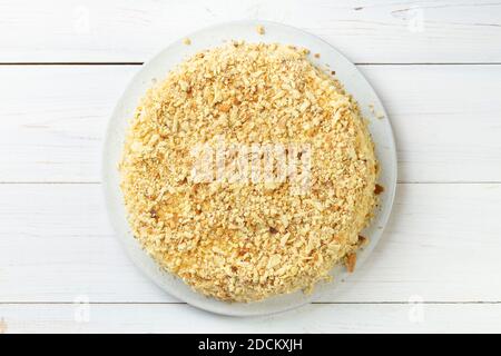 Homemade honey cake with sour cream on a white wooden table. Space for text. Top view. Stock Photo