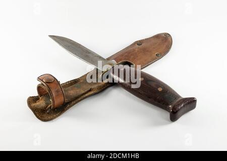 Old rusty vintage hunting bushcraft knife with leather sheath. Isolated on white background, copy space. Stock Photo