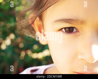 Close-up on the eye of the little girl looking at the camera Stock Photo