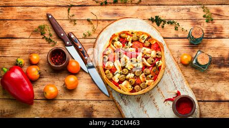 Appetizing tart with cheese, peppers and olives Stock Photo
