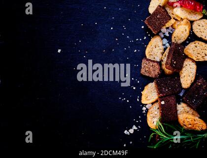 Unhealthy food concept, spicy salted crackers, dark background top view Stock Photo