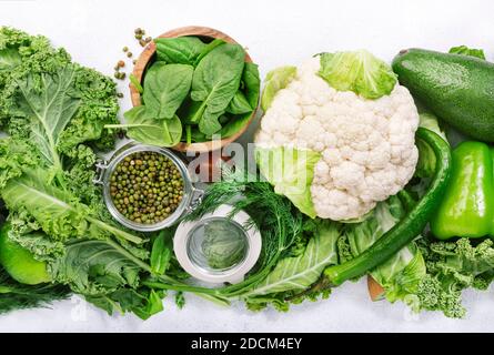 Variety of green vegetables. Healthy food clean eating: vegetable, seeds, superfood, leaf vegetable, herbs on white background, source of vegetarian p Stock Photo
