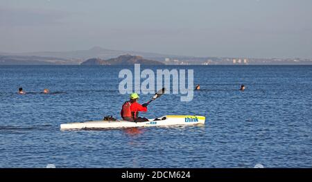 Portobello, Edinburgh, Scotland, UK. 22 November 2020. Temperature of 5 degrees just after sunrise at the seaside, not stopping the cold water swimmers or watersports enthusiasts from braving the chill to boost their thermal energy and wellbeing in the Firth of Forth. Pictured: Think Kayak with Inchkeith island in background. Credit: Arch White/Alamy Live News. Stock Photo