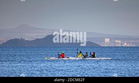 Portobello, Edinburgh, Scotland, UK. 22 November 2020. Temperature of 5 degrees just after sunrise at the seaside, not stopping the cold water swimmers or watersports enthusiasts from braving the chill to boost their thermal energy and wellbeing in the Firth of Forth. Pictured: Think Kayak with Inchkeith island in background. Credit: Arch White/Alamy Live News. Stock Photo