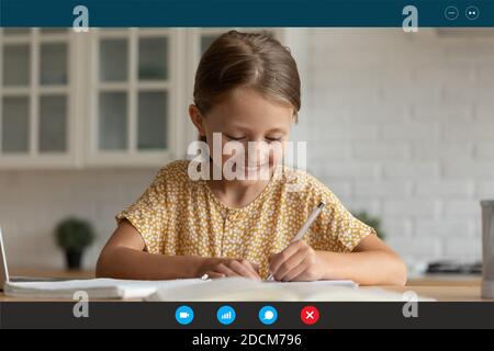 Happy small cute girl studying remotely at home. Stock Photo