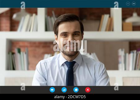 Smiling young successful businessman holding video call online meeting. Stock Photo