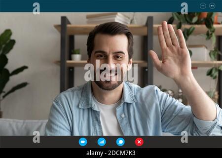 Smiling young handsome man looking at web camera, greeting friends. Stock Photo