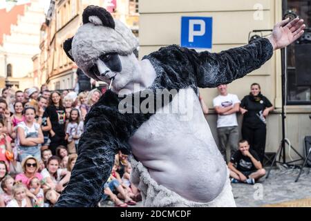 Lublin, Poland - July 26, 2014: Man in panda costume reaching hand to audience at new circus and busking festival Carnaval Sztukmistrzow Stock Photo